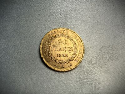 a close up of a gold coin on a gray surface