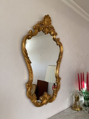 un miroir accroché au mur au-dessus d'une table sur laquelle sont posées des bougies