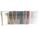 several books are lined up in a row on a white surface