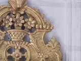 a gold mirror on a white wall with a gold frame