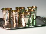 a silver tray with six shot glasses on it
