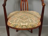 an antique chair with a floral upholstered seat and wooden frame