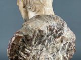 a white marble bust of a man with long hair and a beard