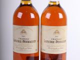 deux bouteilles de vin posées l'une à côté de l'autre sur une surface blanche
