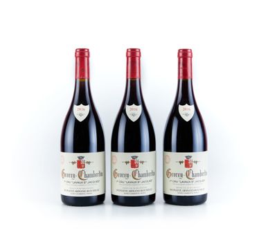 trois bouteilles de vin rouge posées l'une à côté de l'autre sur une surface blanche