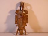 une image représentant une sculpture en bois d'un homme avec un oiseau sur la tête