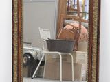 un miroir posé sur le sol devant une chaise