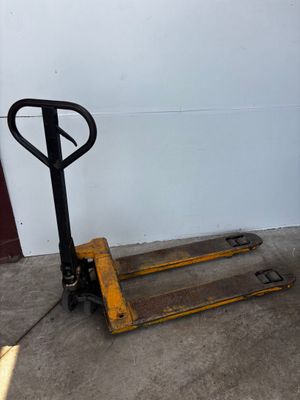 a fork lifter sitting on the floor in front of a white wall