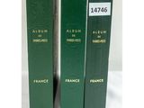 trois livres verts superposés sur une surface blanche