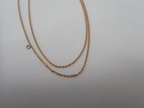 a gold chain necklace with a clasp on a white background