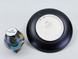 a black bowl and a black and white vase on a table
