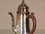 une cafetière en argent posée sur une table en verre