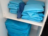 a shelf with a lot of blue towels on it