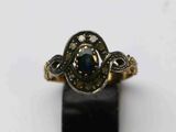 gros plan d'une bague en or avec une pierre bleue