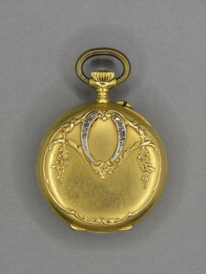 une image représentant une montre de poche en or ornée d'un diamant au centre