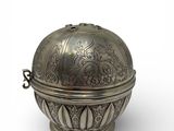 an old silver metal ball with a handle on a white background