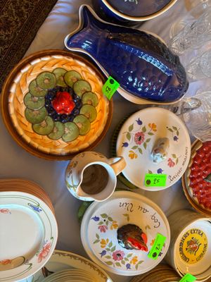 de nombreuses assiettes et bols posés sur une table, avec un vase bleu
