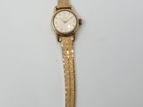 l'image d'une montre en or sur une surface blanche