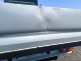 the back end of a white truck with rust on it ' s bumper