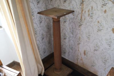 un socle en bois dans un coin de la pièce