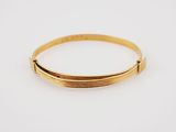 a close up of a gold bracelet on a white background