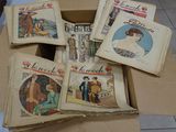 several books in a cardboard box on a tiled floor
