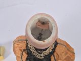a small vase with a chain around it and a brush
