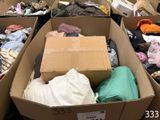 de nombreux cartons remplis de vêtements qui traînent par terre
