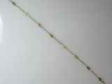 a close up of a gold bracelet on a white surface