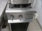 a stove with hotdogs on it in a kitchen