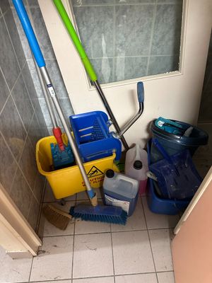 brooms, mops, buckets, and other cleaning supplies in a bathroom