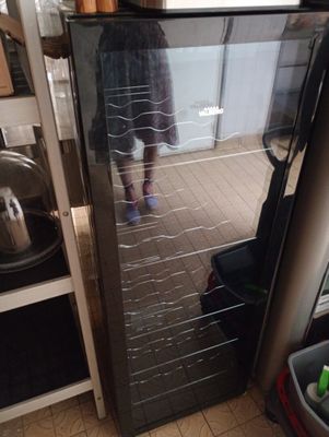 une personne debout devant un réfrigérateur dans une cuisine