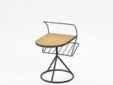 a black metal chair with a wooden seat and a magazine rack