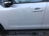 a small white car parked in a parking lot next to a parking meter
