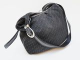 the small black bag is sitting on a white surface
