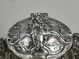 a silver plate with a lid that has a design on it