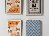 three playing cards sitting next to each other on a white surface