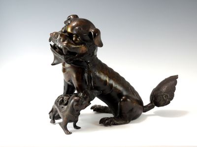 statue en bronze représentant un chien et un chat sur un fond blanc