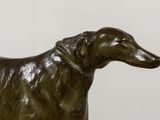 bronze statue of a dog with a collar on a white background