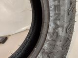 a close up of a tire on a white wall with a black rim