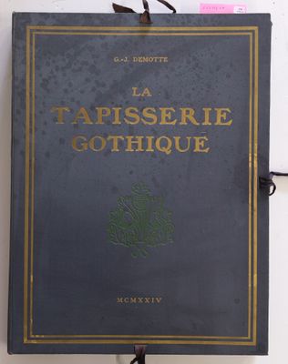la couverture d'un livre avec des lettres dorées sur un mur blanc