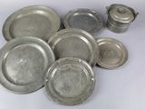 beaucoup d'assiettes en argent sur une table blanche