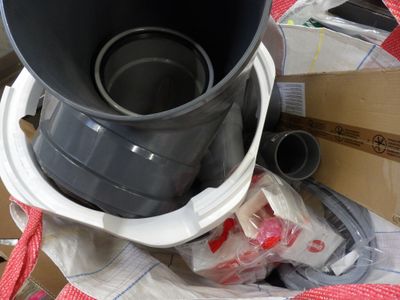 a black bucket with a red handle sitting on top of a pile of boxes