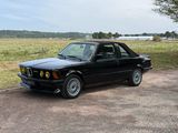 une photo d'une voiture noire garée sur le bord de la route