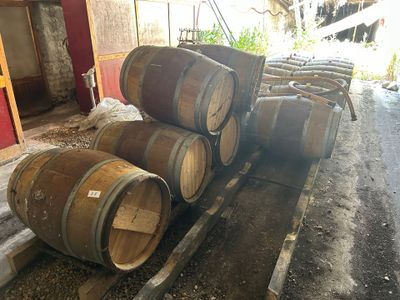 several wooden barrels are stacked on a pallet in a barn