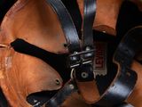 a black helmet with a leather strap and a brown helmet cover
