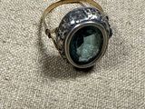 an image of a ring with a green stone in it