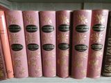 several books are lined up in a row on a shelf