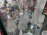 trois vases en verre exposés dans une vitrine