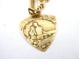 a gold necklace with a picture of jesus on it